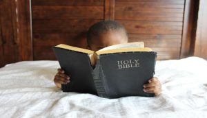 A criança segura a Bíblia