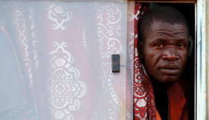 A man peers out of a bus window in Kenya.