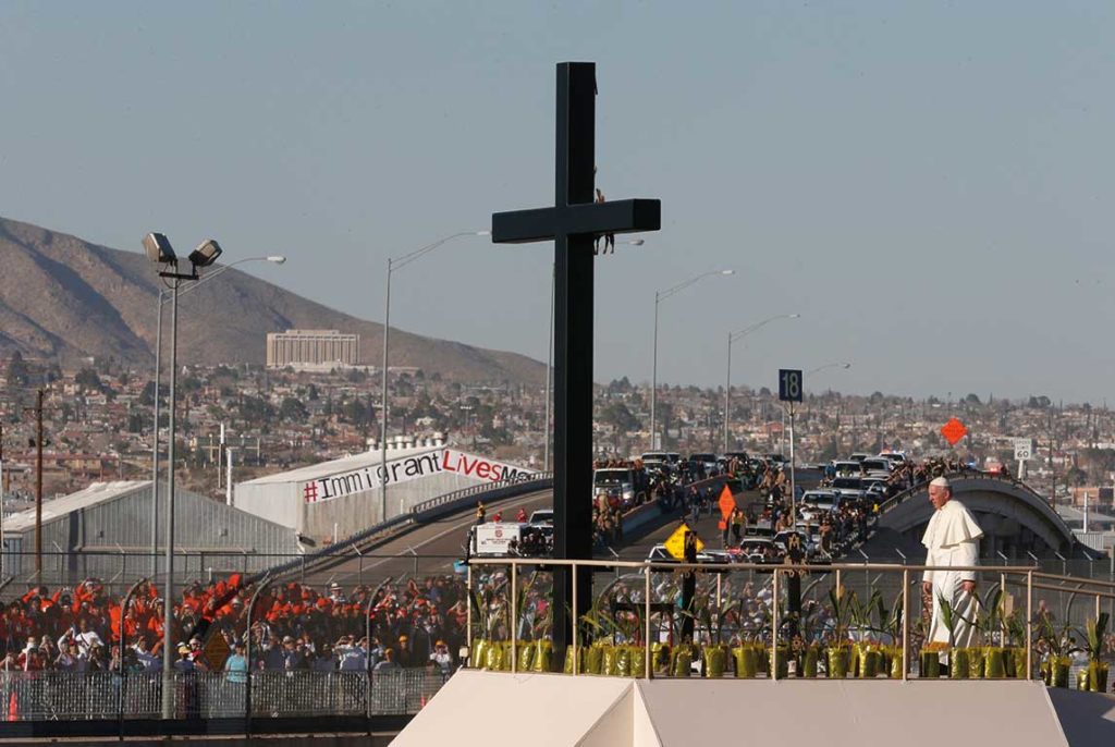 Francisco reza ante una gran cruz situada en la frontera entre México y Estados Unidos.