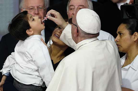 Francisco ofrece una vacuna a un niño.
