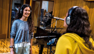 Young girl singing in a recording studio.