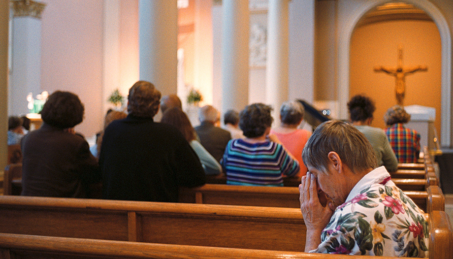 Fieles católicos rezando en una iglesia.